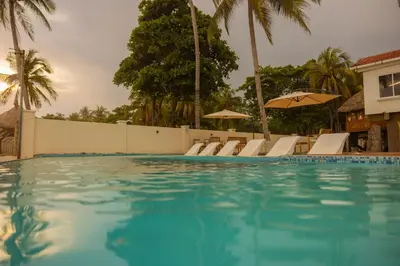 a swimming pool with chairs and umbrellas at The rooftop Beach & club in La Libertad