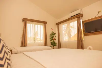 a bedroom with two beds and a tv on the wall at The rooftop Beach & club in La Libertad