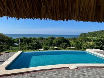 a swimming pool with a view of the ocean at Rancho Agua Fria in Jucuarán