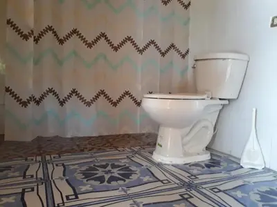 a bathroom with a white toilet in a room at Rancho Agua Fria casa in Usulután