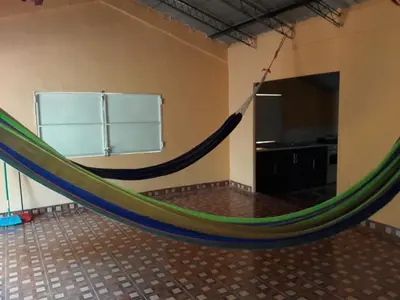 a hammock in the middle of a room at Rancho Agua Fria casa in Usulután