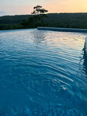 a pool of water with a tree in the background at Rancho Agua Fria casa in Usulután