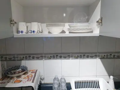 a kitchen with plates and bowls on a shelf at Isabela´s Quality Accommodation in San Salvador