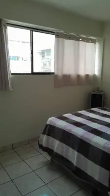 a bedroom with a bed with a checkered blanket and a window at Isabela´s Quality Accommodation in San Salvador