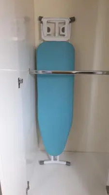 a blue toilet with a shelf on the wall at Isabela´s Quality Accommodation in San Salvador