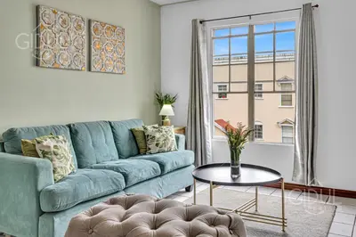 a living room with a blue couch and a table at Comfy & Cozy Apartment in Col Escalon in San Salvador