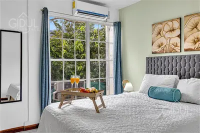 a bedroom with a bed with a table with fruit on it at Comfy & Cozy Apartment in Col Escalon in San Salvador