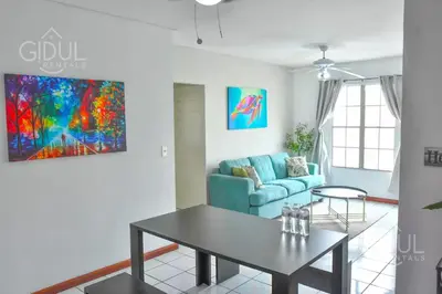 a living room with a blue couch and a table at Comfy & Cozy Apartment in Col Escalon in San Salvador