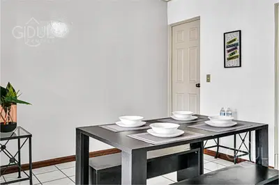 a dining room table with bowls and plates on it at Comfy & Cozy Apartment in Col Escalon in San Salvador