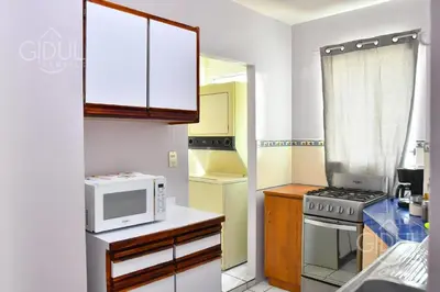 a small kitchen with a microwave and a stove at Comfy & Cozy Apartment in Col Escalon in San Salvador