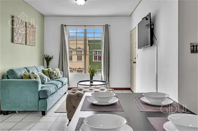 a living room with a couch and a table at Comfy & Cozy Apartment in Col Escalon in San Salvador