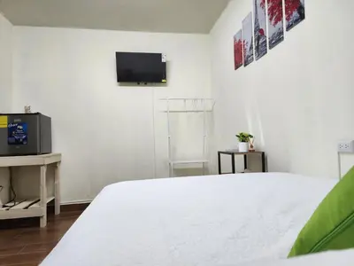 a white bedroom with a bed and a tv at Gywel in San Salvador