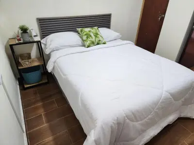 a bed with white sheets and pillows in a bedroom at Gywel in San Salvador