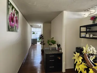 a hallway with a table and flowers on the wall at GYWEL 1214 in San Salvador