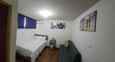 a small bedroom with a bed and a couch at GYWEL1214 3 in San Salvador