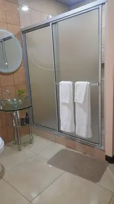 a shower with white towels in a bathroom at Vacacional Abril in Juayúa