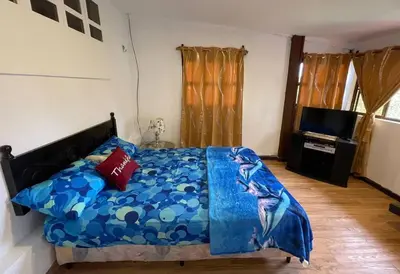 a bedroom with a bed with a blue comforter at Casa Villas Suizas I cerca de Laberinto de Albania in Apaneca