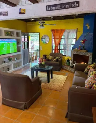 a living room with couches a table and a tv at Casa Villas Suizas I cerca de Laberinto de Albania in Apaneca