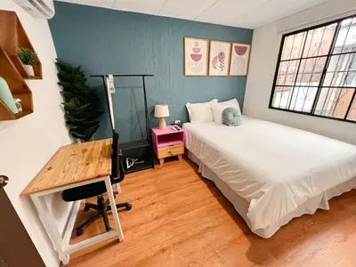 a bedroom with a bed and a desk and a window at Casa 46 - Escalon in San Salvador