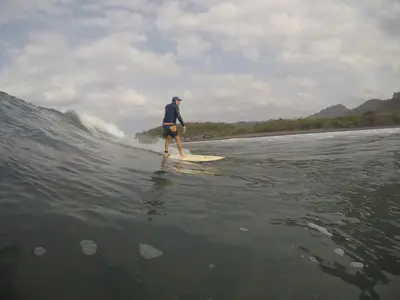 a man riding a wave on a surfboard in the water at Shalpabay House in Taquillo