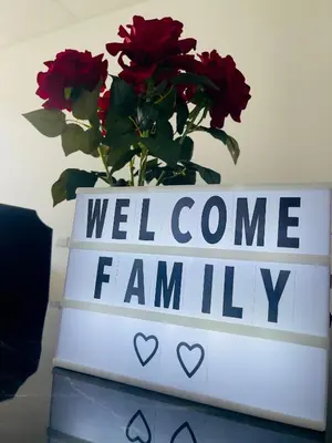a sign that says welcome family with red roses at Stay Loft Mejicanos A 10 min del Centro Histórico in Mexicanos
