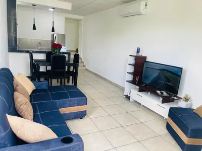a living room with a blue couch and a tv at Stay Loft Mejicanos A 10 min del Centro Histórico in Mexicanos