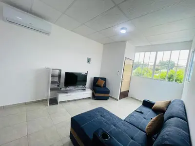 a living room with a blue couch and a tv at Stay Loft Mejicanos A 10 min del Centro Histórico in Mexicanos