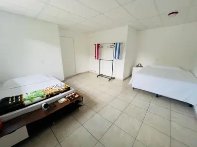 a room with a bed and a table in it at Stay Loft Mejicanos A 10 min del Centro Histórico in Mexicanos