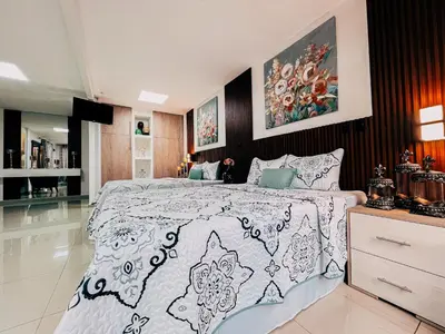 a bedroom with a bed with a black and white comforter at Hotel San Angelo in Concepción de Ataco