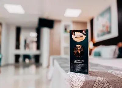 a sign sitting on top of a bed at Hotel San Angelo in Concepción de Ataco