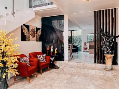 a living room with red chairs and a staircase at Hotel San Angelo in Concepción de Ataco