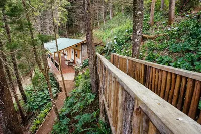 a house in the woods with a wooden fence at Cabaña en las Montañas de El Trifinio in Metapán