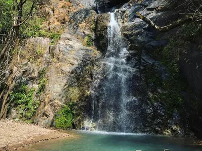 a waterfall on the side of a mountain with a pool of water at Cabaña en las Montañas de El Trifinio in Metapán