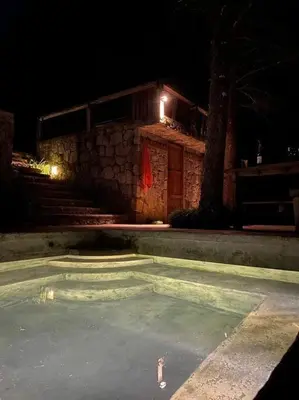a building with a pool of water at night at Cabaña en las Montañas de El Trifinio in Metapán
