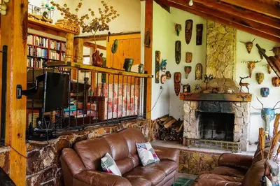 a living room with a couch and a fireplace at Cabaña en las Montañas de El Trifinio in Metapán