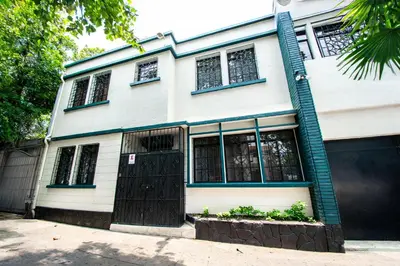 a white and blue house with a black door at Lorenzo Hotel in San Salvador