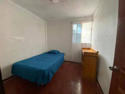 a small bedroom with a blue bed and a window at Casa Juayúa in Juayúa