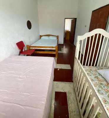 a small room with two beds and a chair at Casa Juayúa in Juayúa