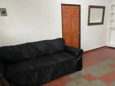 a black couch in a living room with a wooden door at Casa Juayúa in Juayúa