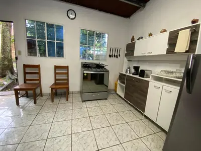 a kitchen with two chairs and a clock on the wall at Casa Juayúa in Juayúa