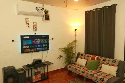 a living room with a couch and a flat screen tv at Las Palmeritas in Ahuachapán