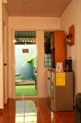 a kitchen with a refrigerator and a door to a yard at Las Palmeritas in Ahuachapán