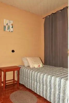 a small bedroom with a bed and a table at Las Palmeritas in Ahuachapán