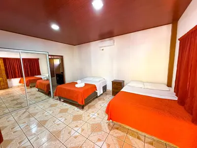 a hotel room with two beds and a shower at Hotel y Restaurante Punta Diamantes in Acajutla