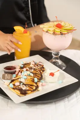 a plate of food with a waffle and a drink at Hotel y Restaurante Punta Diamantes in Acajutla