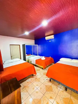 two beds in a room with blue and red walls at Hotel y Restaurante Punta Diamantes in Acajutla