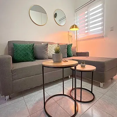 a living room with a couch and two tables at Casa Málaga en San Miguel, El Salvador in San Miguel