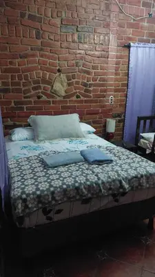 a bed in a room with a brick wall at San Fernando in Concepción de Ataco