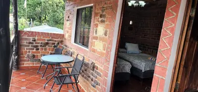 a small patio with a table and chairs on a brick wall at San Fernando in Concepción de Ataco