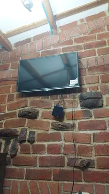 a flat screen tv hanging on a brick wall at San Fernando in Concepción de Ataco